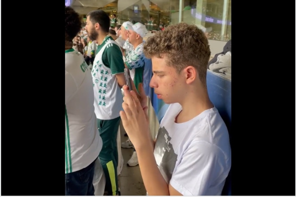 El amor por el fútbol: hincha de Palmeiras con discapacidad ve el partido a través del zoom de su celular.