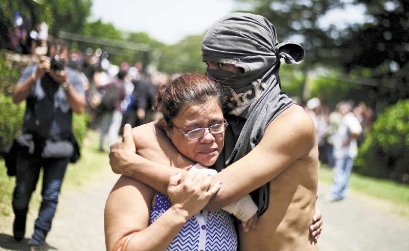 -FOTODELDIA- NI6002. MANAGUA (NICARAGUA), 14/07/2018.- Un estudiante abraza a un familiar hoy, s·bado 14 de julio de 2018, luego de salir del resguardo en la parroquia Divina Misericordia, en Managua (Nicaragua). Al menos dos muertos y dos heridos dejÛ hoy un ataque armado perpetrado por un grupo de policÌas contra estudiantes universitarios que estaban refugiados en la iglesia, informÛ el cardenal nicarag¸ense Leopoldo JosÈ Brenes. EFE/Rodrigo Sura