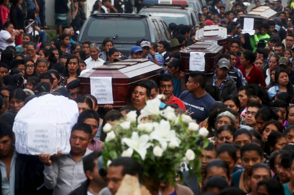 Cientos de personas acompañan los féretros de siete de las víctimas de la erupción del volcán de Fuego. / EFE