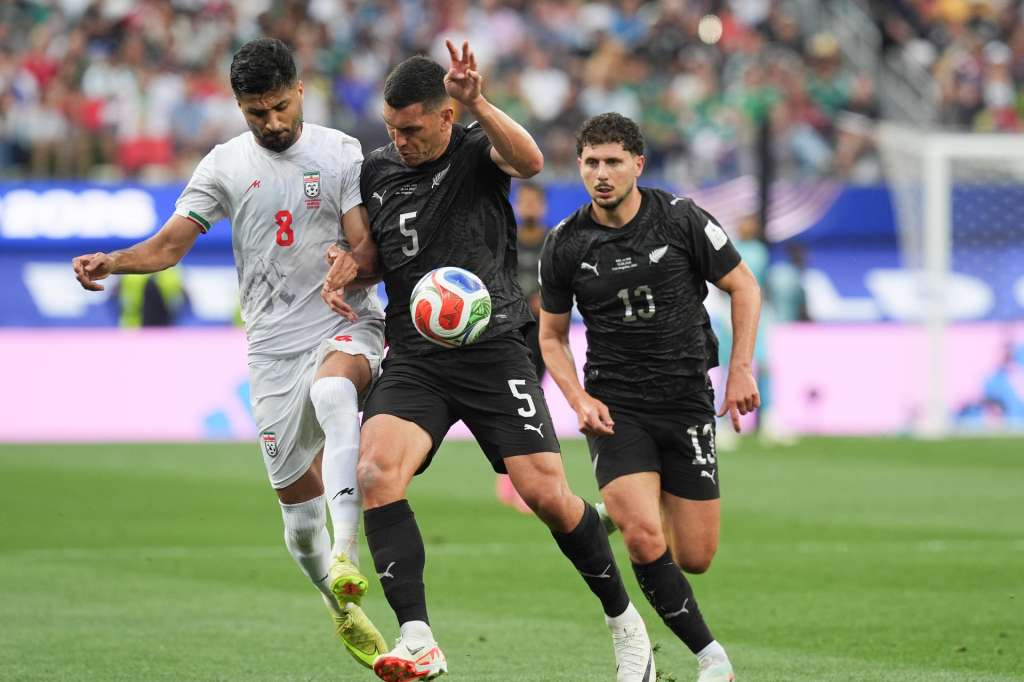 GR2184. LOS ÁNGELES (ESTADOS UNIDOS), 15/06/2026.- Mohammad Mohebbi (i) de Irán disputa el balón con Michael Boxall (c) de Nueva Zelanda este lunes, durante un partido del grupo G del Mundial de la FIFA 2026 entre Irán y Nueva Zelanda en el estadio SoFi en Los Ángeles (Estados Unidos). EFE/ Omar Alonso