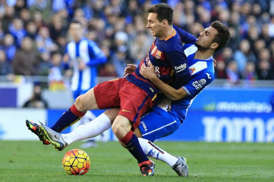 Lionel Messi de Barcelona es marcado por Abraham Gonzalez del Espanyol. / AFP