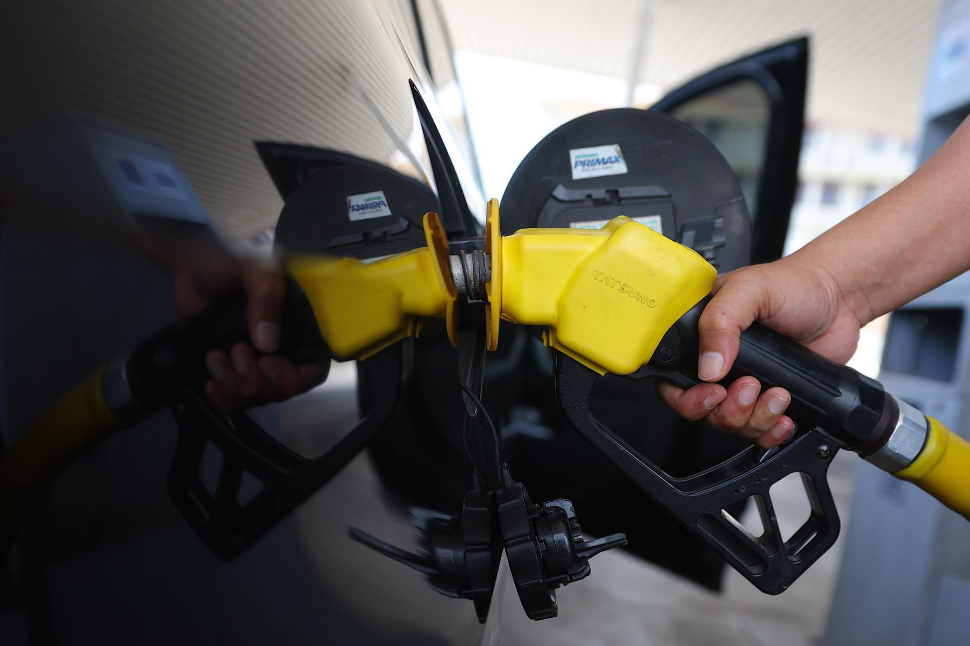 Port Dickson (Malaysia), 25/03/2026.- A man fills his car with petrol at the petrol station in Port Dickson, Negri Sembilan, Malaysia, 25 March 2026. Oil prices dropped on 25 March, with Brent crude falling by 5 percent to USD 99.29 (EURO 74.16) a barrel, after US President Donald Trump signaled negotiations with Iran are taking place. (Malasia) EFE/EPA/FAZRY ISMAIL