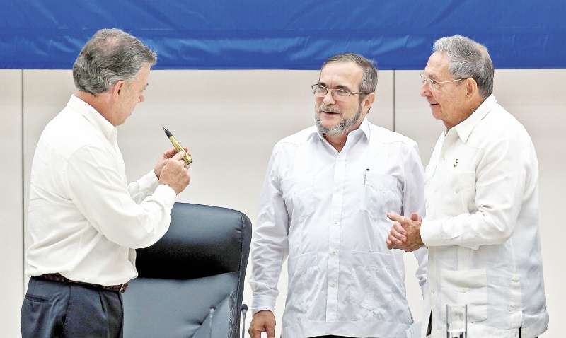 Santos y “Timochenko”, jefe de las Farc, en la firma del acuerdo sobre fin del conflicto, el 23 de junio, con Raúl Castro, presidente cubano, como testigo. / EFE