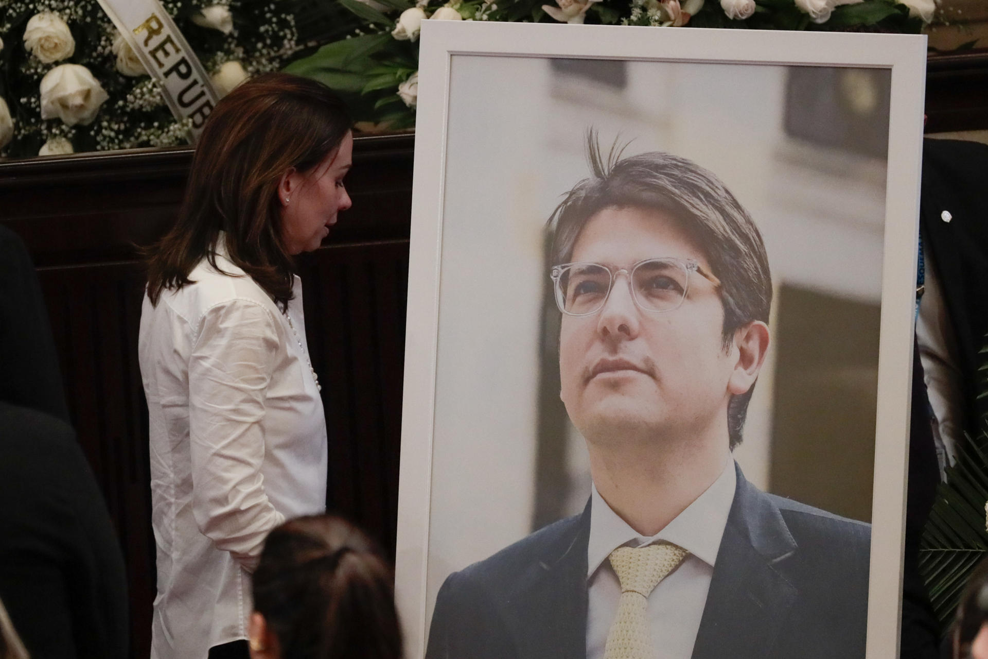 AME9269. BOGOTÁ (COLOMBIA), 11/08/2025.- La esposa del fallecido senador y precandidato a la presidencia de Colombia Miguel Uribe Turbay, Claudia Tarazona, observa un retrato de Miguel este lunes, en el Salón Elíptico del Capitolio Nacional en Bogotá (Colombia). Uribe Turbay falleció después de ser gravemente herido en un atentado hace 64 días. EFE/ Carlos Ortega