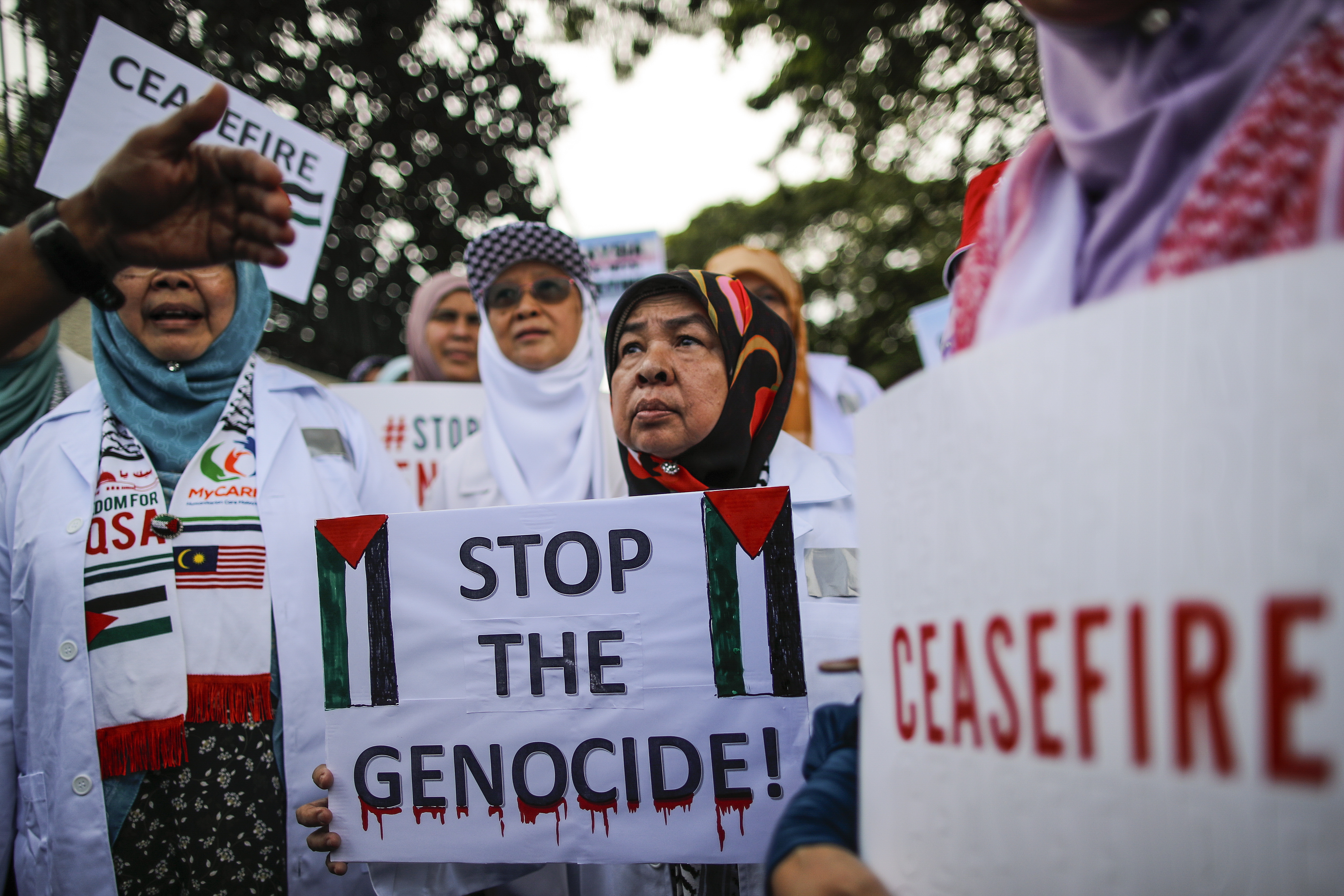 Kuala Lumpur (Malaysia), 16/11/2023.- Malaysian doctors and members of non-governmental organizations (NGO) hold placards during a White Coat Rally outside Egypt's embassy in Malaysia, to show solidarity with Gaza's doctors after Israel launched a military 'operation' inside Al-Shifa Hospital on 15 November; in Kuala Lumpur, Malaysia, 16 November 2023. On 15 November the largest hospital in Gaza - Al Shifa hospital - was raided by the Israeli Army. Under the Geneva Convention, hospitals must be protected, according to a press statement by Doctors And Healthworkers Against Genocide. (Egipto, Malasia, Ginebra) EFE/EPA/FAZRY ISMAIL