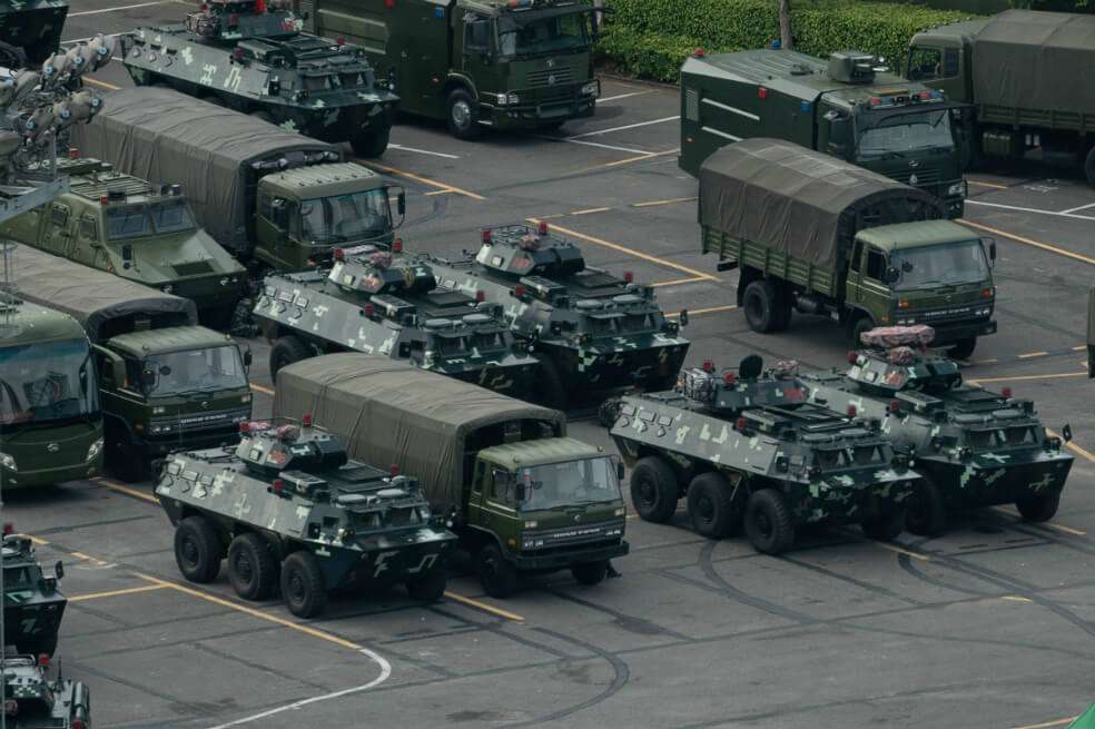 Camiones y vehículos blindados se ven estacionados en el estadio de la Bahía de Shenzhen en Shenzhen, en la frontera con Hong Kong en el sur de China. Beijing aumenta sus belicosas amenazas contra Hong Kong para mermar las protestas en esta región especial que están a punto de cumplir tres meses. / AFP