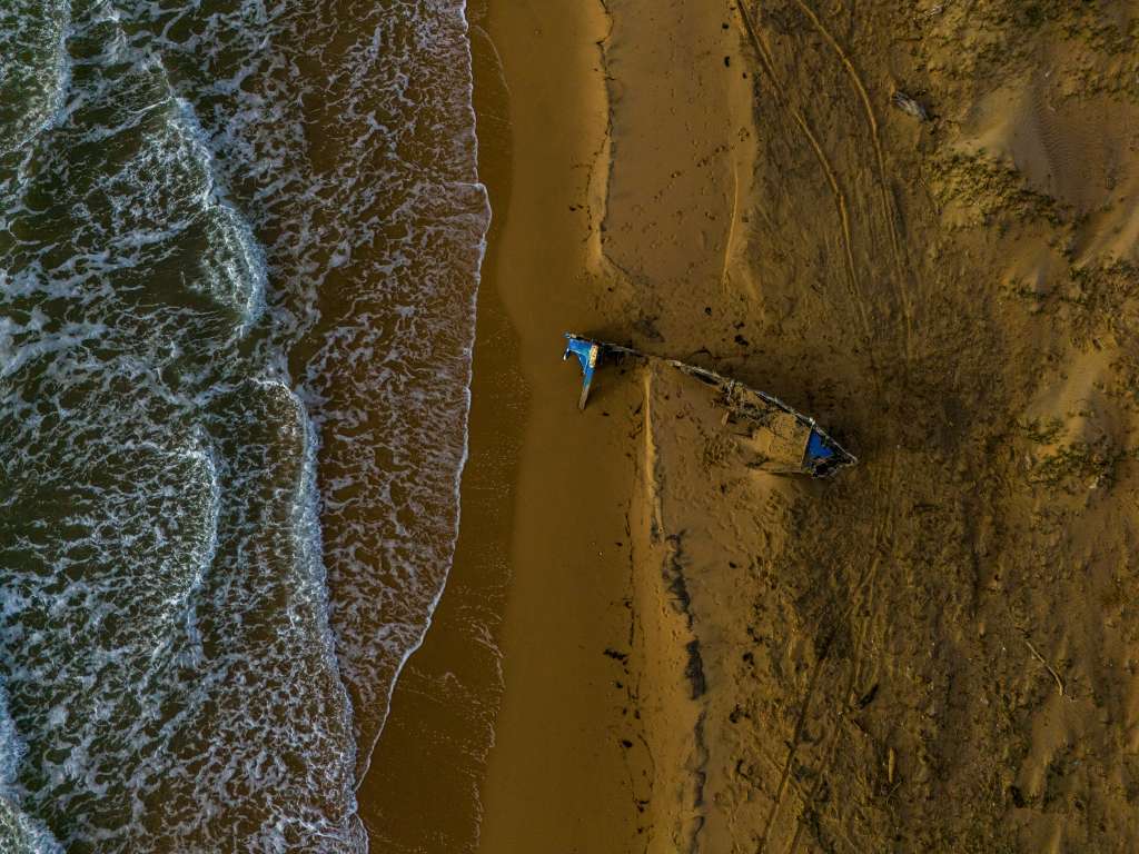 Restos de una embarcación quemada en la playa cerca de Puerto López, Colombia, el 21 de diciembre de 2025.