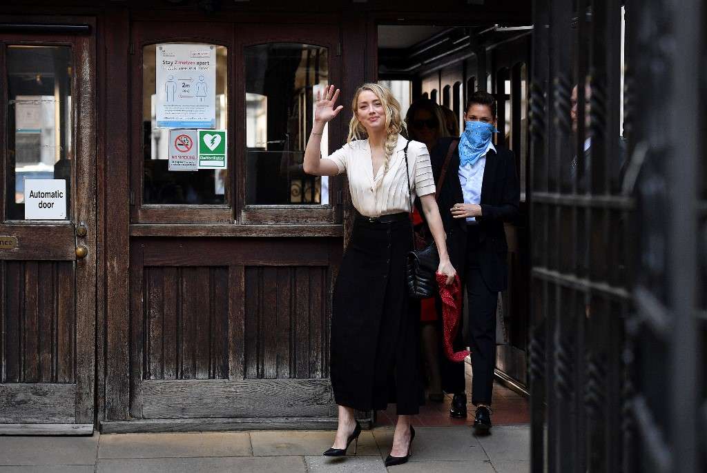 Amber Heard, vestida con una falta larga de color negro y una blusa blanca, llegó al juicio de Johnny Depp contra The Sun por difamación. La artista insiste en que el actor amenazó con matarla muchas veces.
