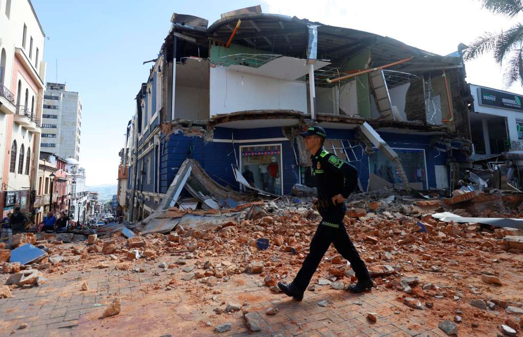 AME7622. MANIZALES (COLOMBIA), 10/08/2026.- Un integrante de la Policía de Colombia camina frente a una edificación afectada tras un fuerte temblor este lunes, en Manizales (Colombia). Al menos dos personas murieron en la capital del departamento de Caldas, en el centro del país, por el terremoto de magnitud 7,4 que sacudió buena parte del territorio nacional, según informó el alcalde de esa ciudad, Jorge Eduardo Rojas Giraldo. EFE/ John Jairo Bonilla