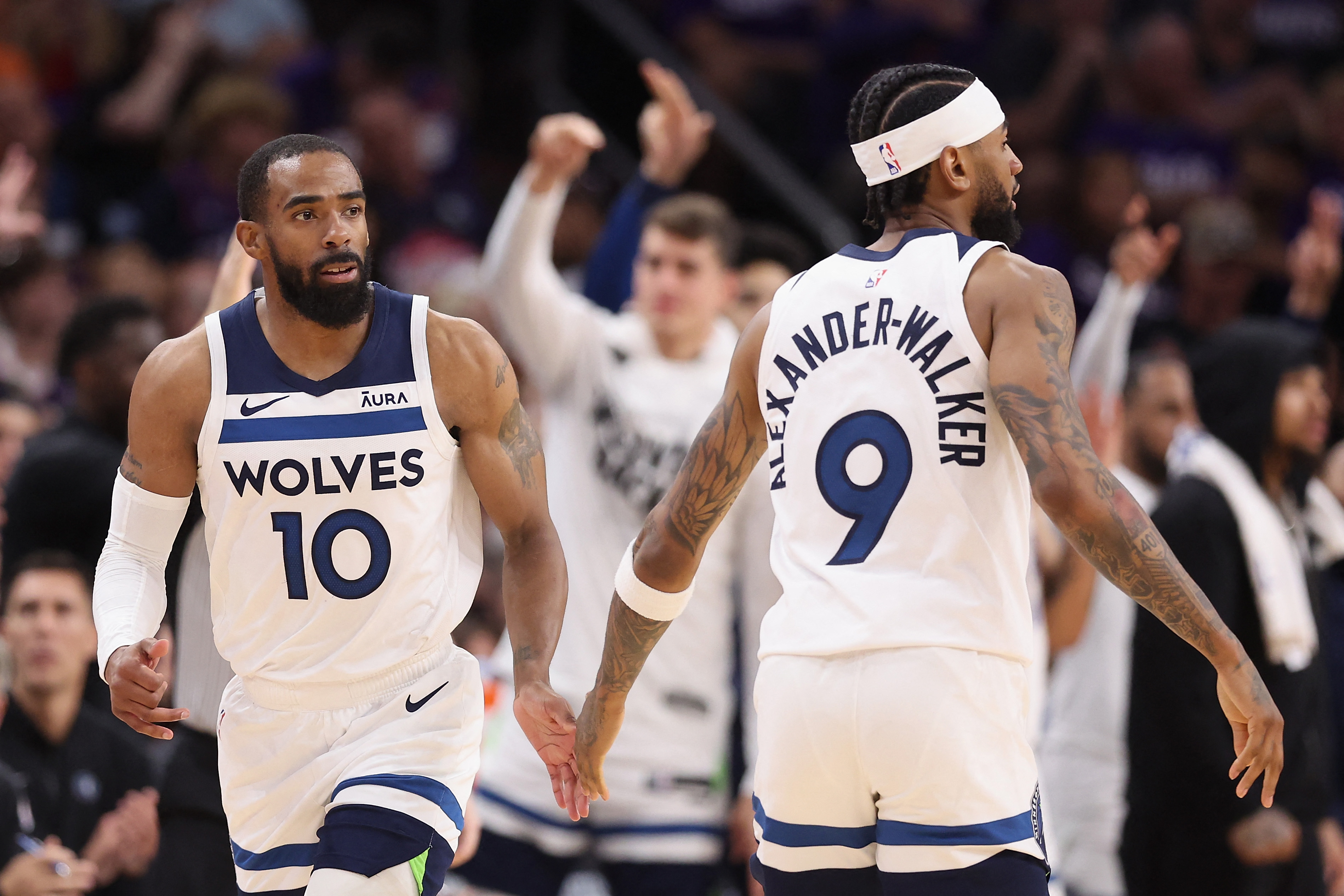 Mike Conley (izq.) de los Minnesota Timberwolves choca los cinco con Nickeil Alexander-Walker después de un tiro de tres puntos contra los Phoenix Suns durante la segunda mitad del cuarto partido de los 'play-offs ' de Primera Ronda de la Conferencia Oeste.