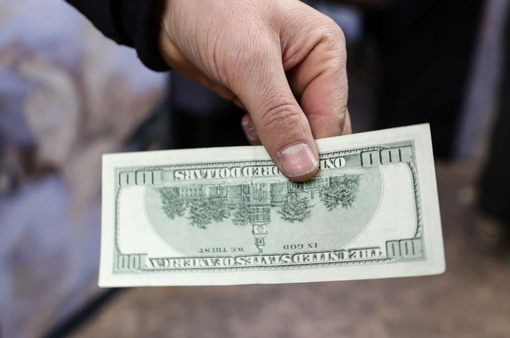 Istanbul (Turkey), 27/11/2024.- A man shows a 100-dollar bill after his request to convert US Dollars to Turkish lira was rejected, at the Grand Bazaar in Istanbul, Turkey, 27 November 2024. According to Board member of the Foreign Exchange Bureaus Associations (TUYEMDER), Mustafa Unver the authorized exchange offices temporarily stopped buying and selling 50- and 100-dollar bills after an alert of counterfeit dollar bills circulating in Turkey, adding that money counting machines and ATMs cannot detect the counterfeit nature of these banknotes. (Turquía, Estanbul) EFE/EPA/ERDEM SAHIN