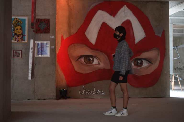 Un joven de perfil, junto a un grafiti