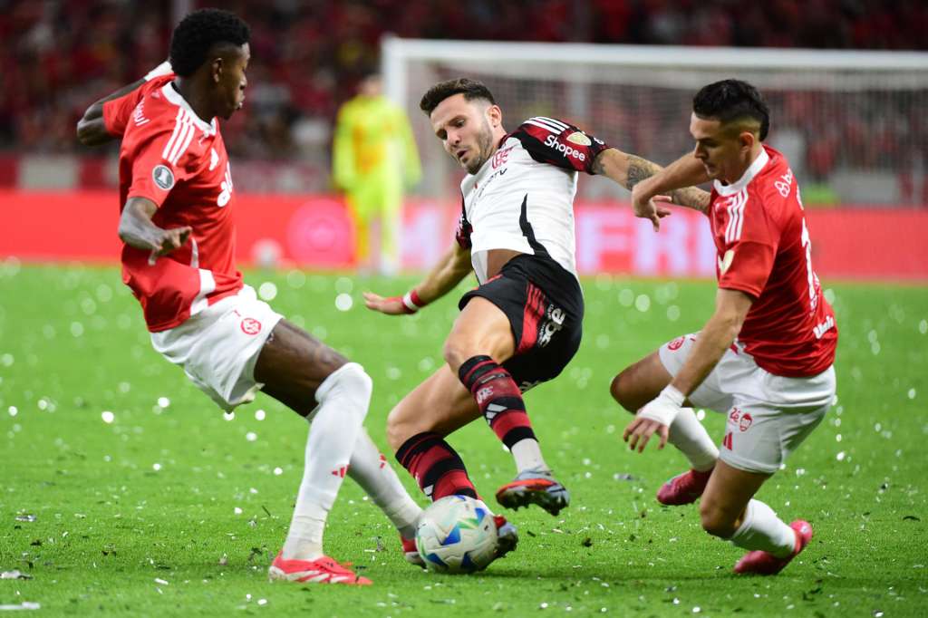 AMDEP1356. PORTO ALEGRE (BRASIL), 20/08/2025.- Vitao (i) y Rafael Santos Borré (d) de Internacional disputan el balón con Saúl Ñíguez de Flamengo este miércoles, en un partido de los octavos de final de la Copa Libertadores entre Internacional y Flamengo en el estadio Estadio Beira-Rio en Porto Alegre (Brasil). EFE/ Ricardo Rimoli