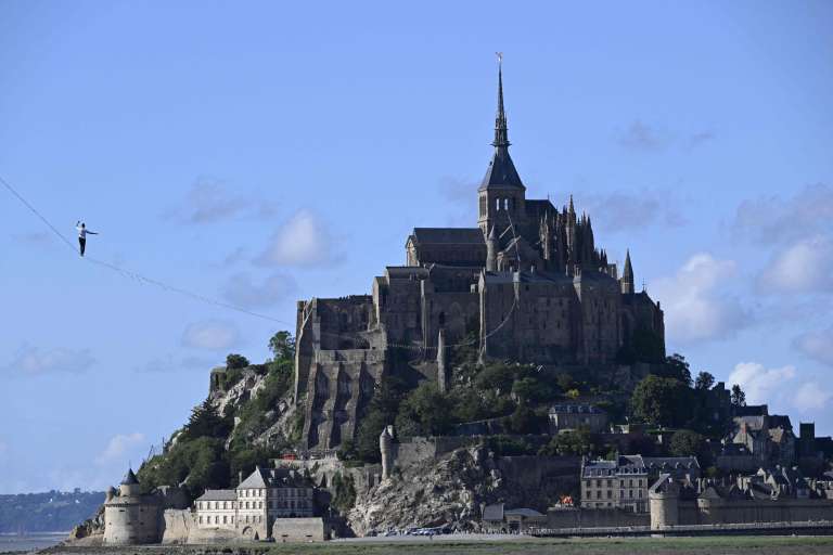 El equilibrista francés Nathan Paulin camina sobre una cuerda floja en la bahía de Le Mont Saint-Michel, en el noroeste de Francia, durante su intento de récord mundial de distancia