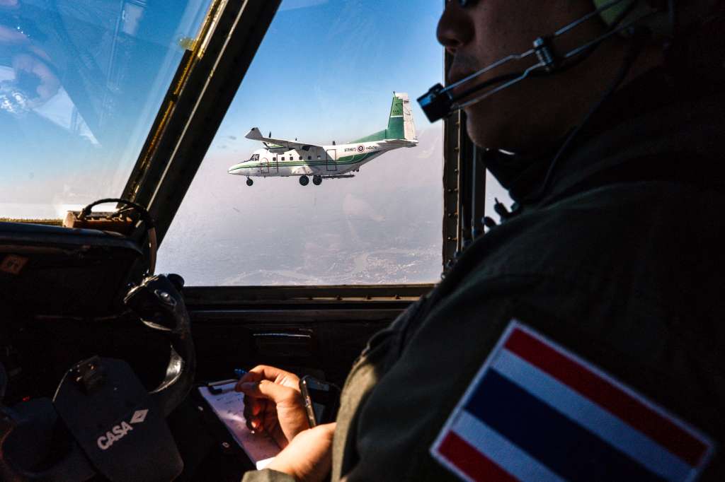 CORRECTION / This photo taken on January 15, 2025 shows a pilot flying next to another aircraft from Thailand's Royal Rainmaking department taking part in an atmospheric modification mission to displace pollution by spraying icy water in the air on the outskirts of Bangkok.