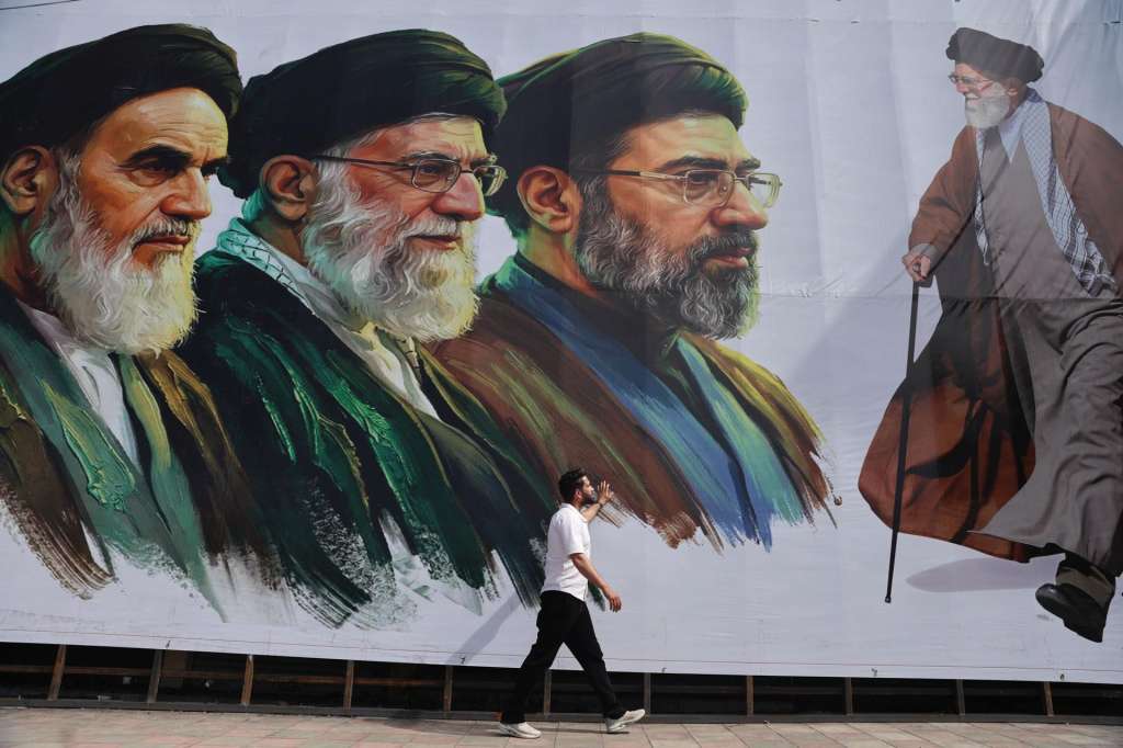 FOTODELDÍA EPA1585. SRINAGAR (INDIA), 22/04/2026.- Un hombre pasa frente a una valla en la que aparecen los retratos del nuevo líder supremo de Irán, el ayatolá Mojtaba Jamenei, el difunto líder supremo, el ayatolá Ali Jamenei, y el difunto líder supremo, el ayatolá Ruhollah Jomeini este miécoles, en Srinagar (India). EFE/ Farooq Khan
