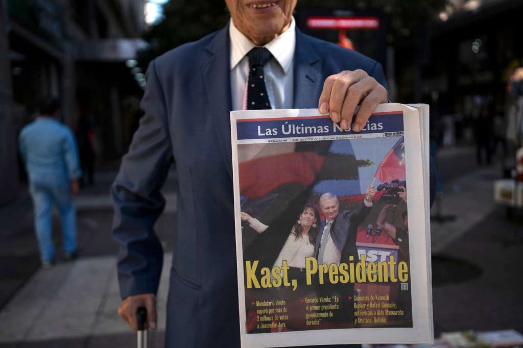 AME8413. SANTIAGO (CHILE), 15/12/2025.- Un hombre sostiene un periódico que anuncia los resultados de las elecciones presidenciales, este lunes en Santiago (Chile). Chile dio un giro este domingo a la ultraderecha con el triunfo arrollador en las elecciones presidenciales de Kast, que se convierte en el primer pinochetista en llegar al poder tras el fin de la dictadura hace 35 años. EFE/ Adriana Thomasa