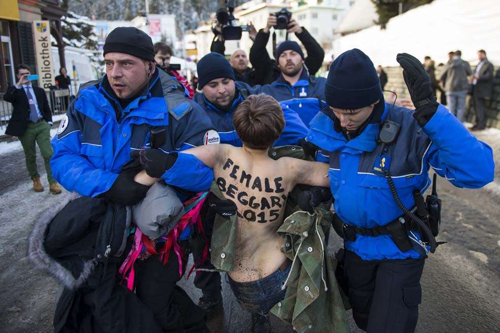 Una activista del movimiento feminista Femen, detenida por agentes de policía suizos durante la 45 edición del Foro Económico Mundial, esta semana en Davos (Suiza). Protestó por falta de inclusión en la cumbre cuyo tema central es “El nuevo contexto global”. / EFE