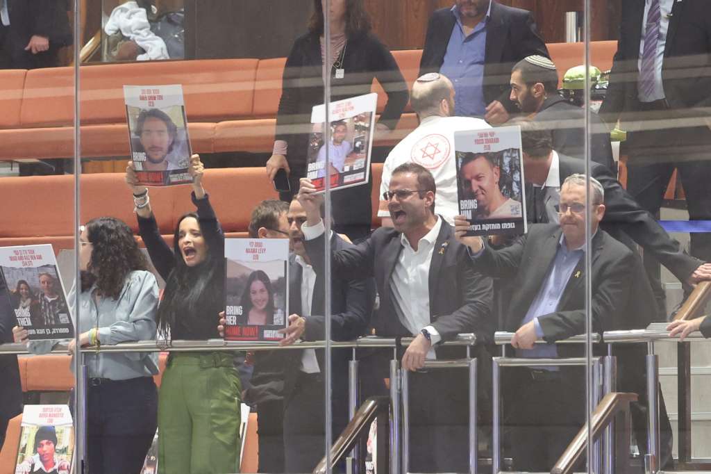 Jerusalem (Ó-), 18/11/2024.- Unidentified opposition MPs show pictures of hostages as Israeli Prime Minister Benjamin Netanyahu addresses a discussion called on by the opposition on the release of the Israeli hostages held by Hamas, at the Knesset in Jerusalem, Israel, 18 November 2024. According to Israel's military, around 100 Israeli hostages remain in captivity in the Gaza Strip, including the bodies of 33 confirmed dead. (Jerusalén) EFE/EPA/ABIR SULTAN