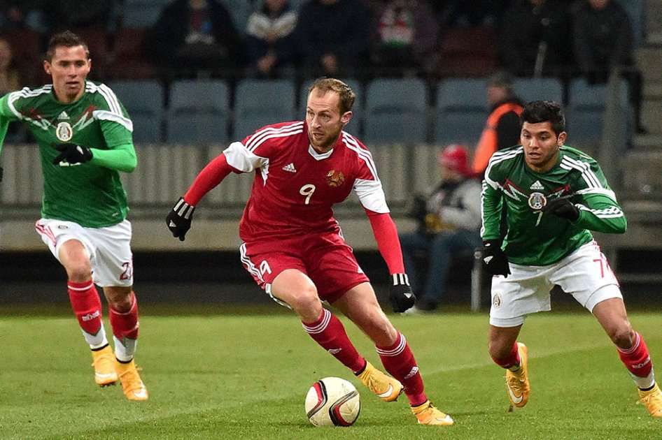 El delantero Igor Stasevih (Bielorrusia) disputa el balón con Paul Aguilar y Jesús Corona (México). Foto: AFP