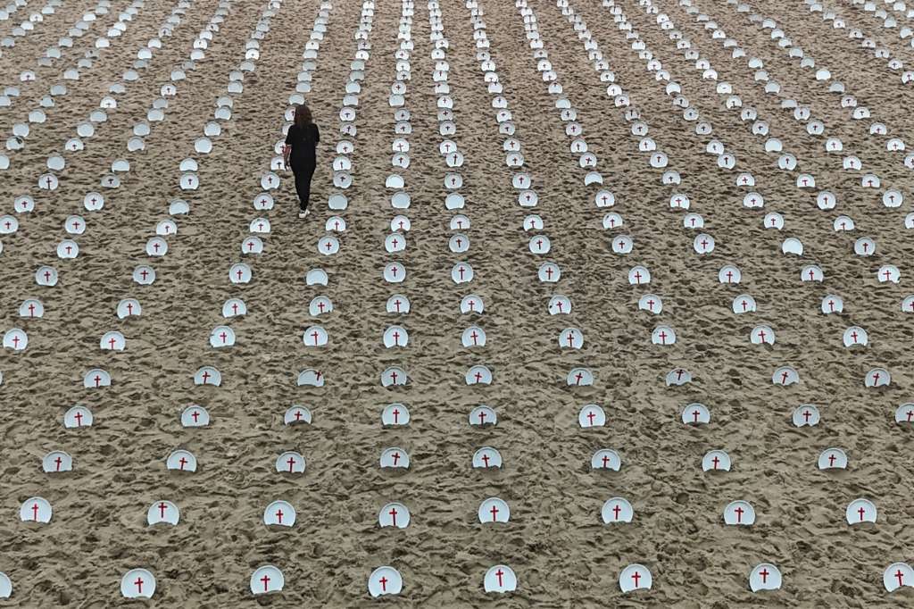 -FOTODELDÍA- AME7797. RÍO DE JANEIRO (BRAZIL), 16/11/2024.- Fotografía aérea de una activista del grupo de derechos humanos Rio de Paz, colocando una de los 733 platos con una cruz roja en la playa de Copacabana, este sábado, en Río de Janeiro (Brasil). Antes de la Cumbre del G20, se instó a los líderes mundiales a combatir el hambre con una manifestación de platos vacíos que representan a los 733 millones de personas que padecen hambre, según datos de la ONU. EFE/ Antonio Lacerda