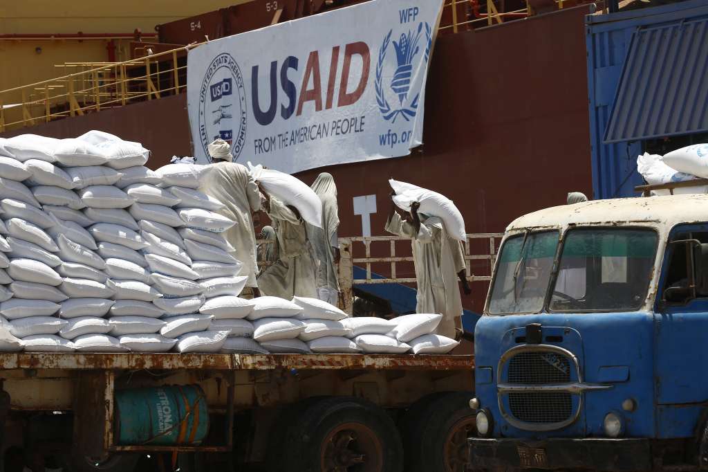 (FILES) Sudanese dockers unload bags of sorgham (cereal) from one of two US ships carrying humanitarian aid supplies provided by the US development agency USAID, at Port Sudan on the red sea coast on June 5, 2018.