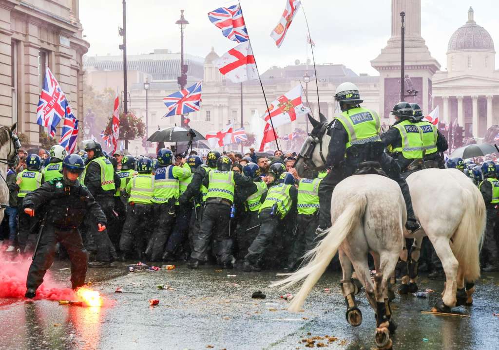 LONDON (United Kingdom), 13/09/2025.- Flares are thrown as protesters taking part in a 'Unite the Kingdom' rally are held back by police officers, in central London, Britain, 13 September 2025. Two opposing demonstrations, involving tens of thousands of participants, are currently underway in London. A far-right 'Unite the Kingdom' rally led by activist Tommy Robinson, and a counter-protest by anti-racism campaigners under the banner of 'Stand Up to Racism.' (Protestas, Reino Unido, Londres) EFE/EPA/TAYFUN SALCI
