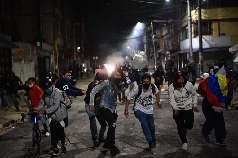 Un grupo de personas encapuchadas corren de frente