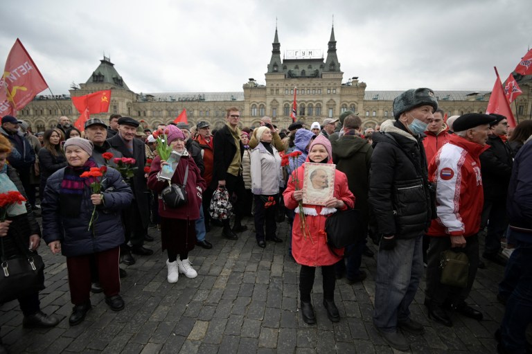 Una niña simpatizante del Partido Comunista Ruso cargando una foto de Lenin en la Plaza Roja de Moscú.