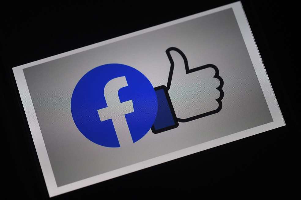 (FILES) This file photo illustration taken on March 25, 2020 shows a Facebook App logo displayed on a smartphone in Arlington, Virginia. - Facebook said on February 23, 2021 it will lift a contentious ban on Australian news pages "in the coming days", after the government agreed to amend a world-first media law fiercely opposed by the tech giant. (Photo by Olivier DOULIERY / AFP)
