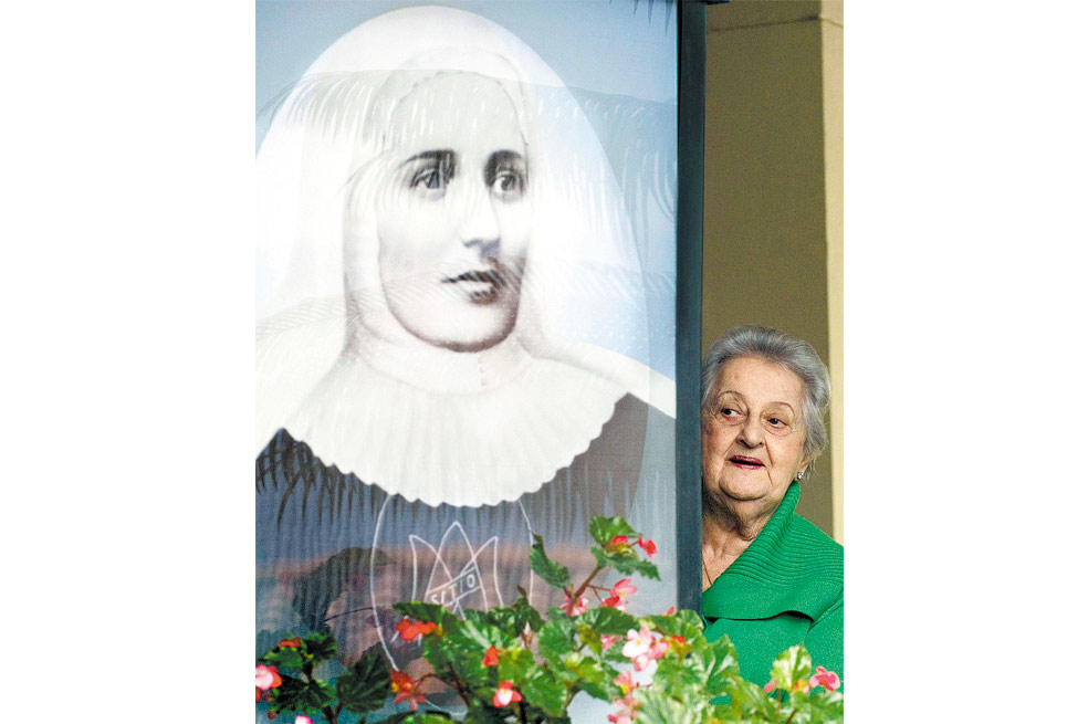 Una mujer pasa junto a una imagen de la Madre Laura en el convento donde vivía en Medellín. / AFP
