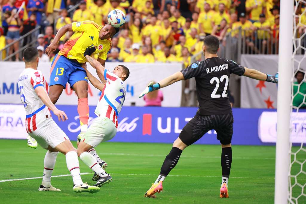 Yerry Mina de Colombia cabecea el balón en el área penal durante el partido del Copa América 2024 entre Colombia y Paraguay.