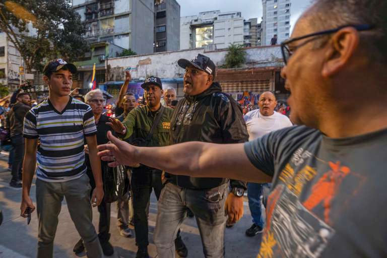 AME6018. CARACAS (VENEZUELA), 28/07/2024.- Agentes intervienen en enfrentamientos entre seguidores del presidente de Venezuela y candidato a la reelección, Nicolás Maduro, con opositores este domingo, en Caracas (Venezuela). Varias decenas de motorizados que se identificaron como chavistas llegaron a un centro de votación en Caracas, donde se encontraban testigos opositores y ciudadanos que esperaban el comienzo del escrutinio de las elecciones presidenciales de este domingo, lo que dio lugar a una confrontación que acabó a golpes, ante la mirada impasible de los policías, que no intervinieron para detener la pelea. EFE/ Henry Chirinos