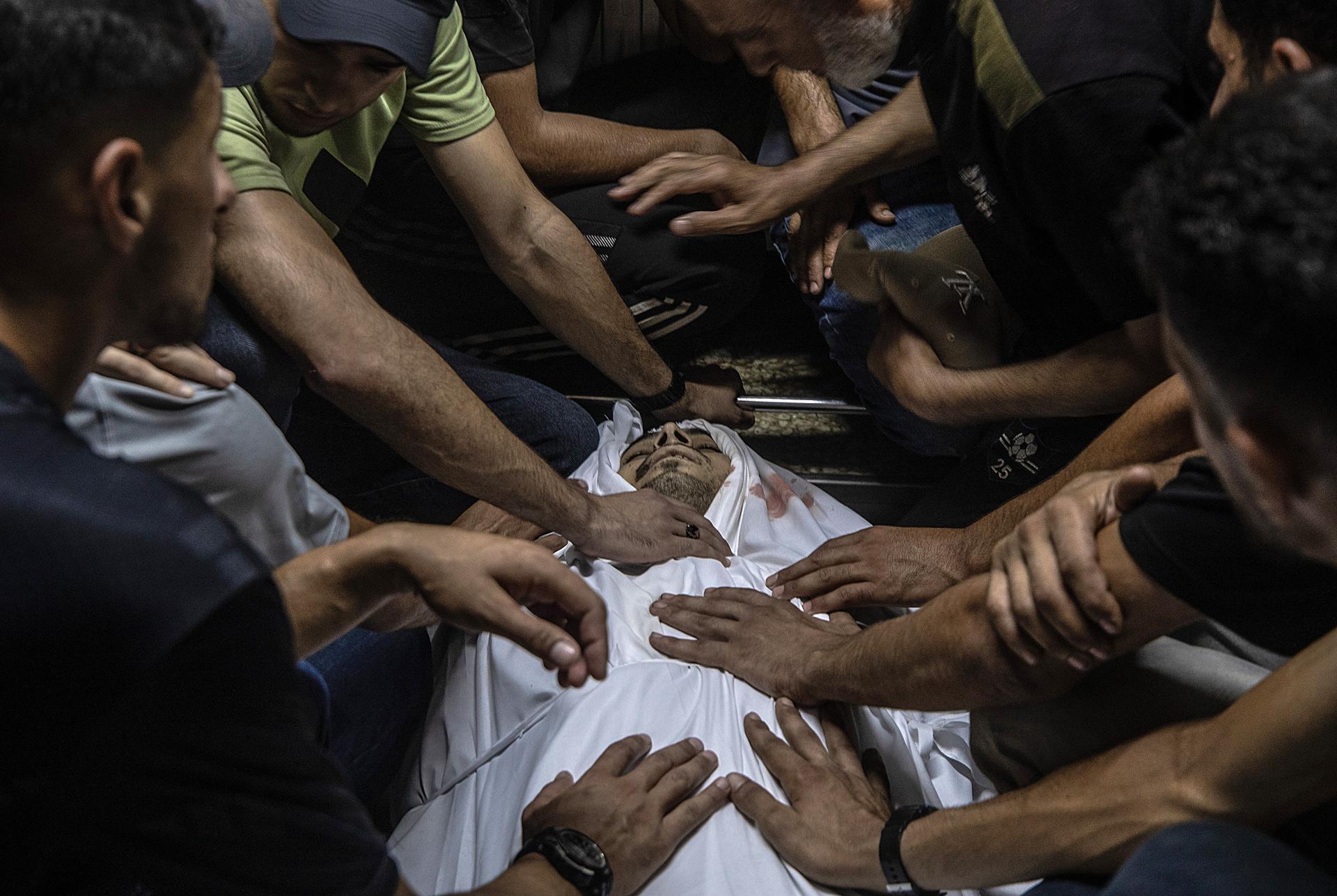 GAZA CITY (---), 14/07/2026.- GRAPHIC CONTENT - Palestinians mourn over the body of former Hamas policeman Abed Almalek Abu Jobein at Al-Shifa hospital in Gaza City, 14 July 2026. At least seven Palestinians were killed in an Israeli attack on a police station in Jabalia, northern Gaza, according to the Gaza Health Ministry. EFE/EPA/MOHAMMED SABER -- ATTENTION EDITORS: GRAPHIC CONTENT --