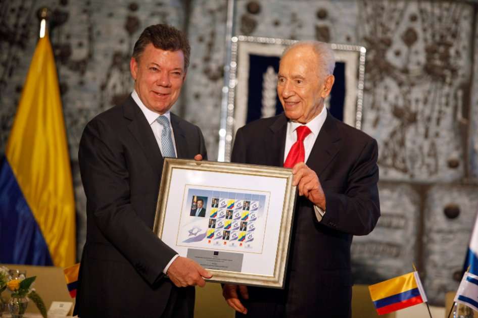El presidente de Colombia, Juan Manuel Santos, recibe un regalo de su homólogo israelí, Simon Peres, en la residencia presidencial en Jerusalén (Israel).