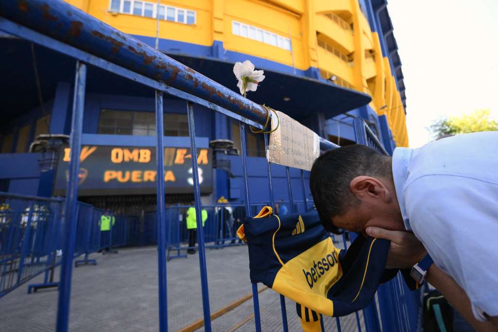 Un aficionado del fallecido entrenador argentino Miguel Ángel Russo besa una camiseta de Boca Juniors en las afueras del estadio La Bombonera antes de su velorio en Buenos Aires, el 9 de octubre de 2025.