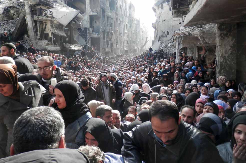 Imagen del campo de refugiados palestinos en Siria de Yarmuk, cientos de personas hicieron largas filas para recibir alimentación proporcionada por la agencia de la ONU, UNRWA. En el lugar se ha alertado sobre graves casos de desnutrición e insalubridad. / AFP