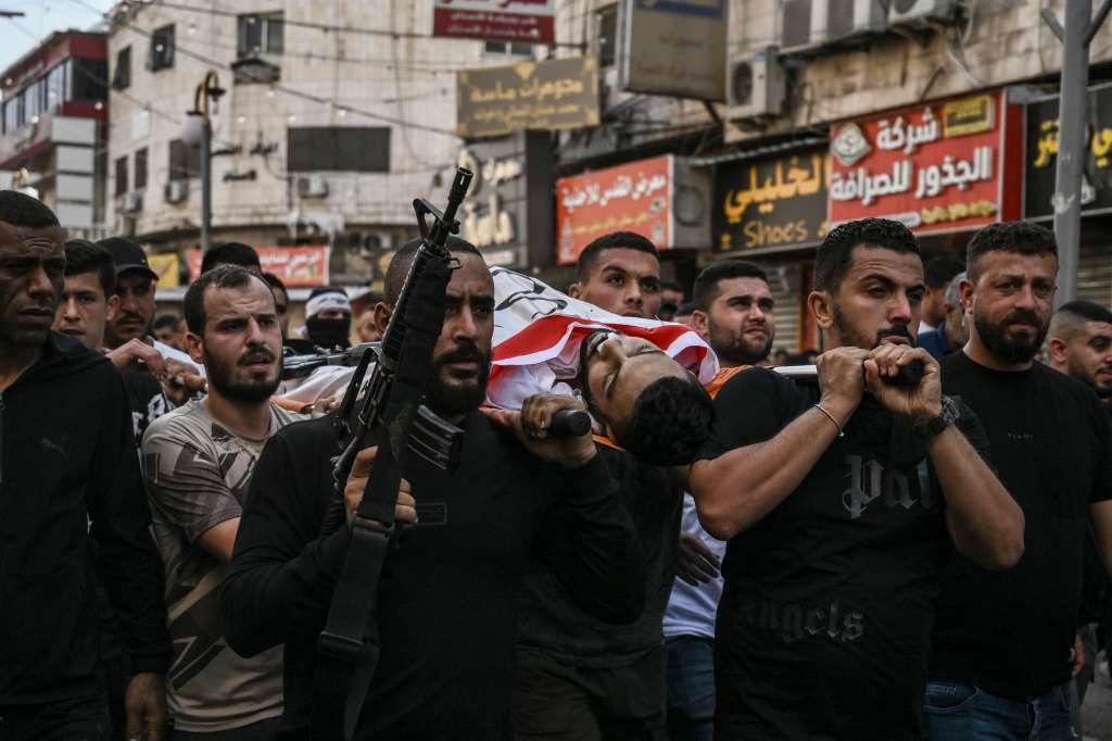 Palestinos cargan el cuerpo de un hombre muerto durante una incursión nocturna y enfrentamientos con el ejército israelí en el campo de refugiados de Jenin, cerca de la ciudad de Jenin, en el norte de Cisjordania ocupada por Israel.