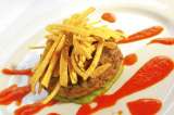 Hamburguesa de ternera sobre puré de arveja con salsa de tomate