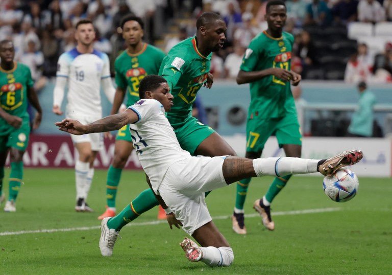 . JOR (CATAR), 04/12/2022.- Marcus Rashford (abajo) de Inglaterra disputa un balón hoy, en un partido de los octavos de final del Mundial de Fútbol Qatar 2022 entre Inglaterra y Senegal en el estadio Al Bait en Jor (Catar). EFE/Antonio Lacerda