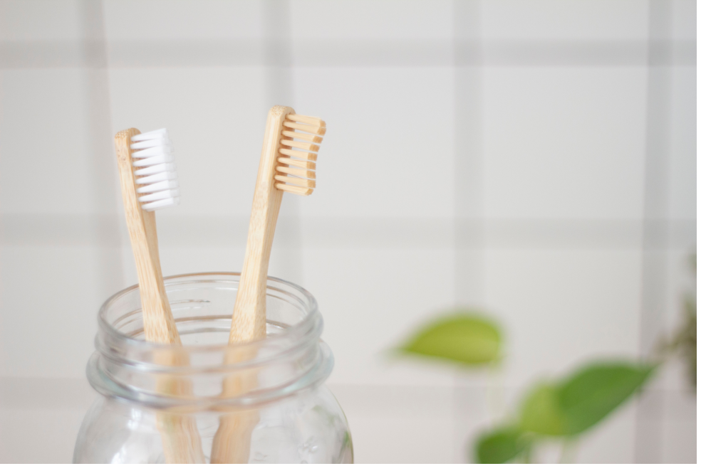 Dos cepillos de dientes de bambú en un vaso