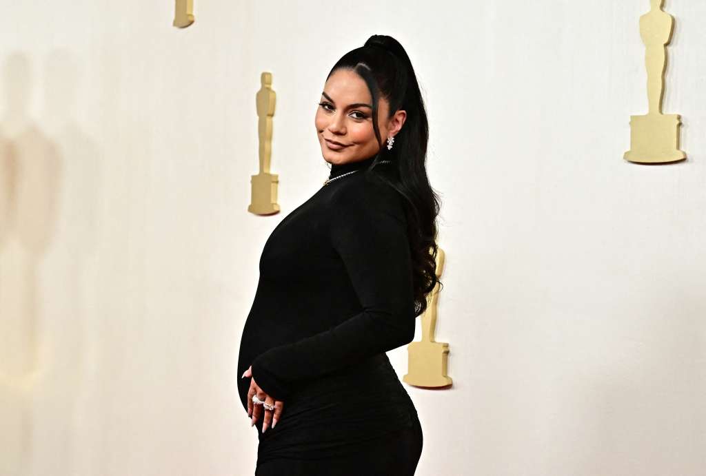 La actriz Vanessa Hudgens fue de las primeras en llegar enfundada en un vestido negro reveló que está esperando su primer bebé. / AFP