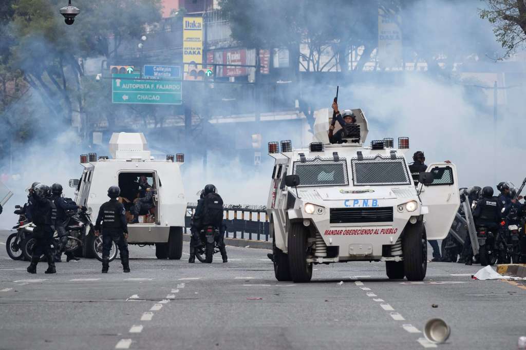 AME6374. CARACAS (VENEZUELA), 29/07/2024.- Integrantes de la Policía Nacional Bolivariana (PNB) enfrentan a manifestantes opositores este lunes, durante una protesta contra de los resultados de las elecciones presidenciales, en Caracas (Venezuela). EFE/ Ronald Peña R.