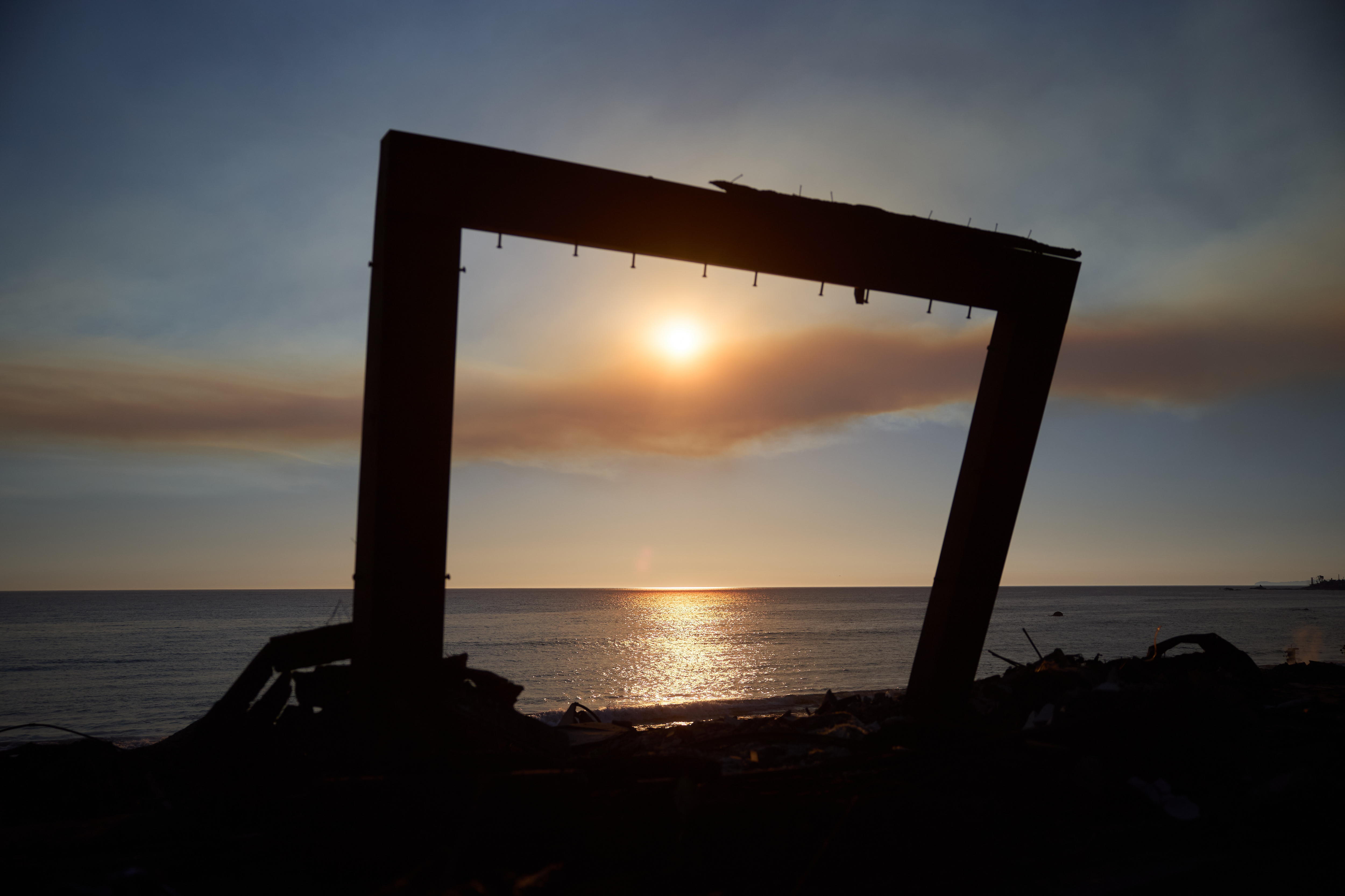 FOTODELDÍA MALIBU (EEUU), 11/01/2025.- Atardecer sobre en el Océano Pacífico visto a través de los restos de una casa destruida por el incendio forestal que se inició en Pacific Palisades, en Malibú, California, EE.UU., este sábado. EFE/ Allison Dinner