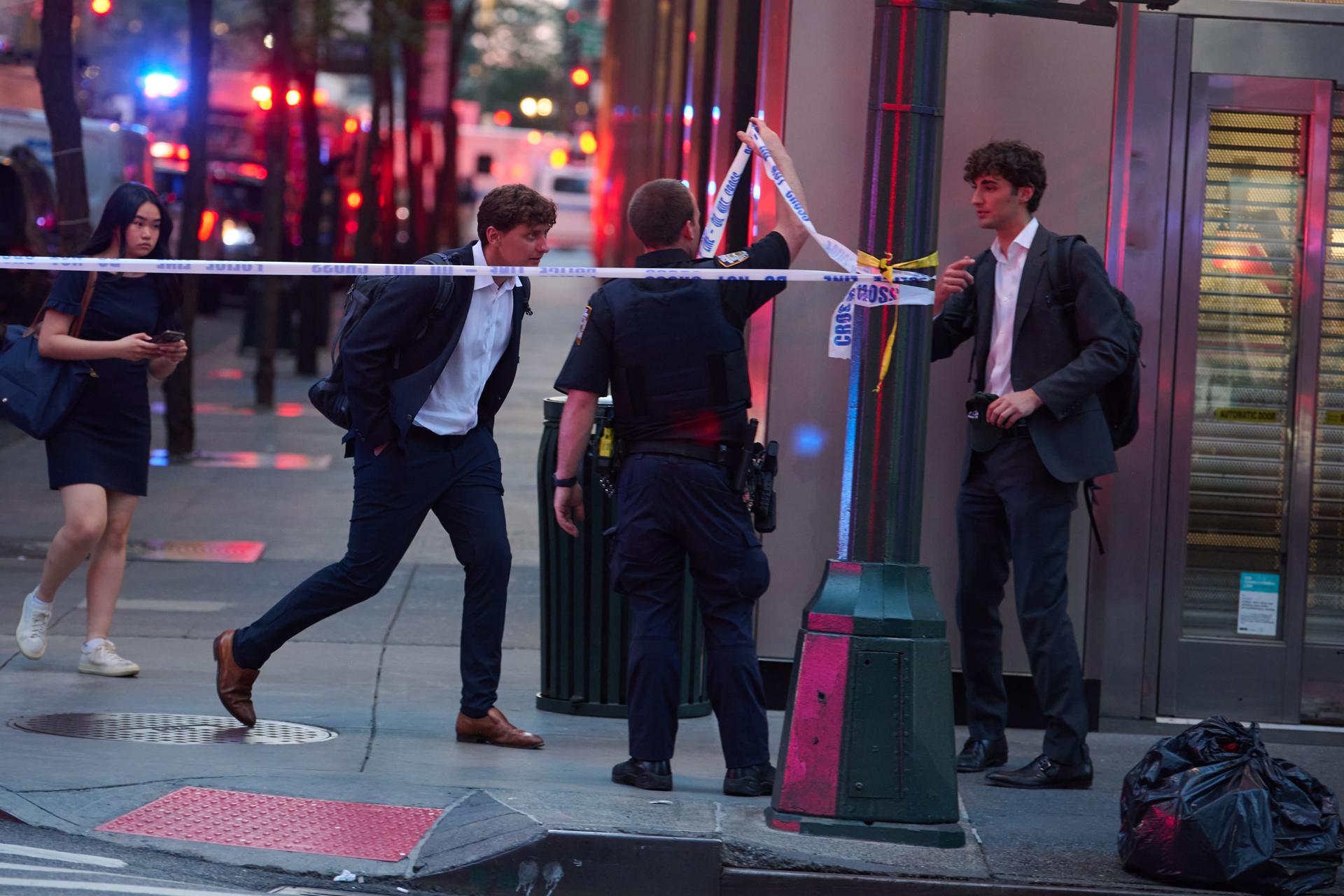 NEW YORK (United States), 28/07/2025.- Pedestrians walk through a barricade as New York City Police Officers respond to an active shooter incident in midtown, occurring inside at 345 Park Ave, in New York, New York, USA, 28 July 2025. Police officials confirmed the shooter was 'neutralized' Monday night. (Nueva York) EFE/EPA/LLOYD MITCHELL