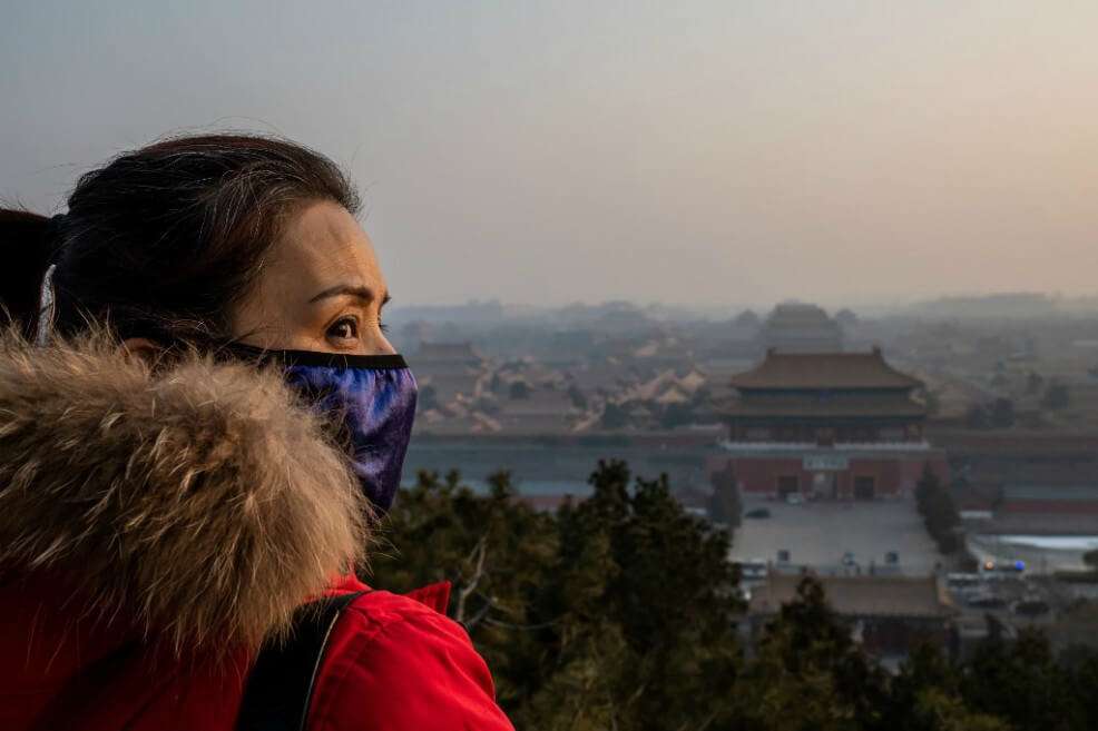Una mujer con tapaboocas en la ciudad de Wuhan, epicentro de la epidemia. / AFP