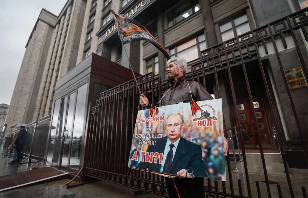 Moscow (Russian Federation), 03/10/2022.- A man holds banner reads as 'ÄòWe are with him. And you? For the sovereignty of Russia'Äô standing outside the Russian State Duma building in Moscow, Russia, 03 October 2022. The State Duma, the lower house of the Federal Assembly of Russia, ratified agreements on the admission of four new subjects to the Russian Federation: the Donetsk and Luhansk People's Republics, Kherson and Zaporizhzhia regions of Ukraine. From 23 to 27 September, residents of the self-proclaimed Luhansk and Donetsk People's Republics as well as the Russian-controlled areas of the Kherson and Zaporizhzhia regions of Ukraine voted in a so-called 'referendum' to join the Russian Federation. Putin held a signing ceremony to annex the four areas last week. (Rusia, Ucrania, Moscú) EFE/EPA/YURI KOCHETKOV