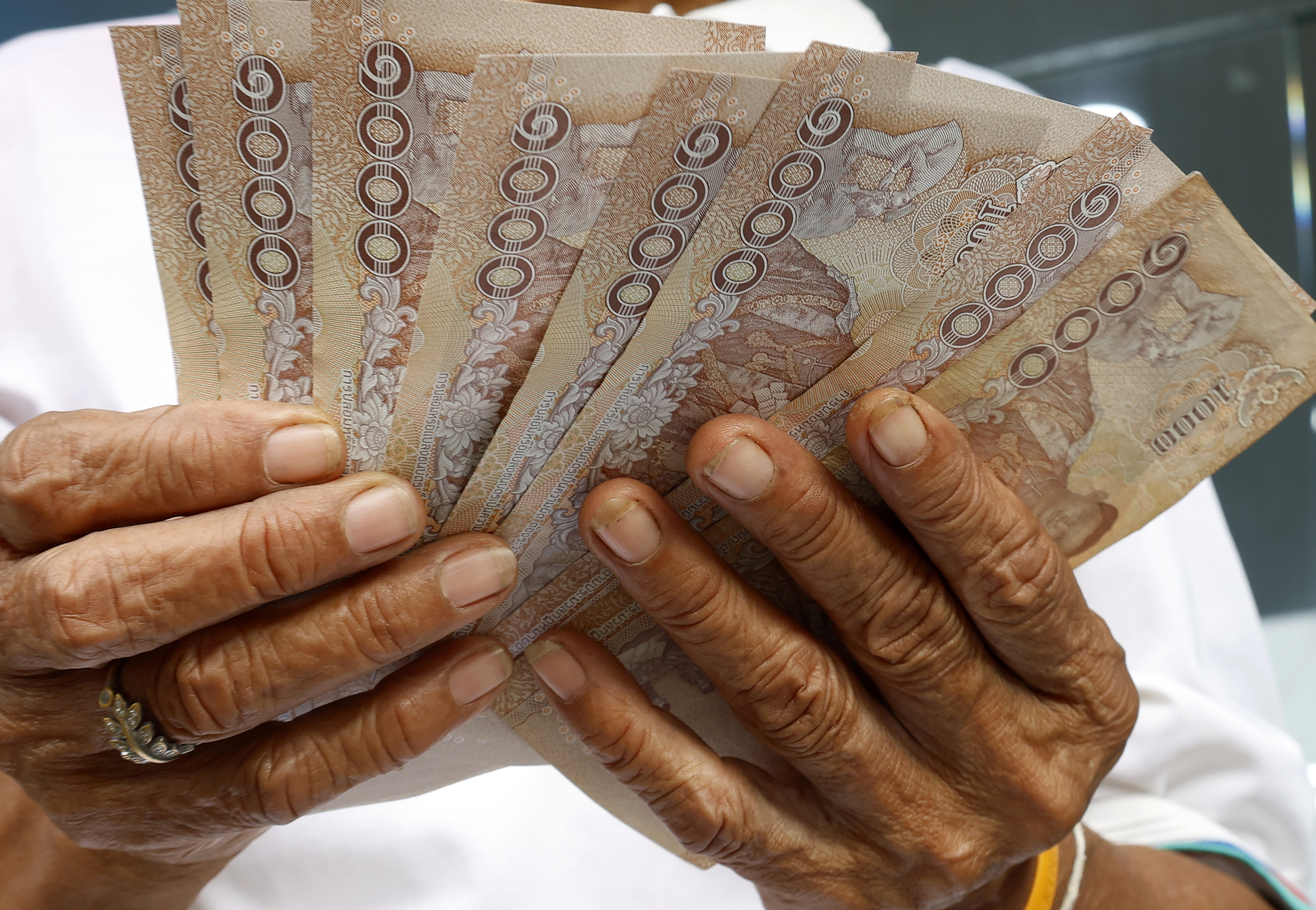 Bangkok (Thailand), 26/09/2024.- A local carries banknotes after withdrawing money following receiving a deposit of 10,000 Thai baht into their account under the government's digital wallet scheme, in front of a bank in Bangkok, Thailand, 26 September 2024. The Thai government is giving a cash payment of 10,000 Thai baht (about 306 US dollars or 275 euros) to welfare cardholders and the disabled. This is part of the government's 2024 economic stimulus projects, which will distribute a total of 145 billion Thai baht (about 4.3 billion US dollars or 3.9 billion euros) in cash to vulnerable people. The government hopes that this will help to alleviate the financial burdens of these people and stimulate the economy. (Tailandia) EFE/EPA/NARONG SANGNAK