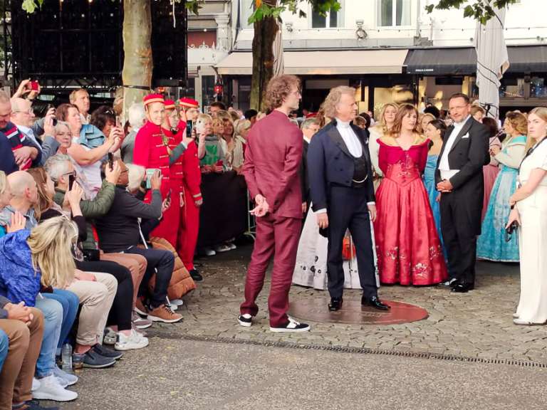 André Rieu inicia su camino hacia el escenario al lado de su orquesta. Su hijo Pierre lo acompaña.