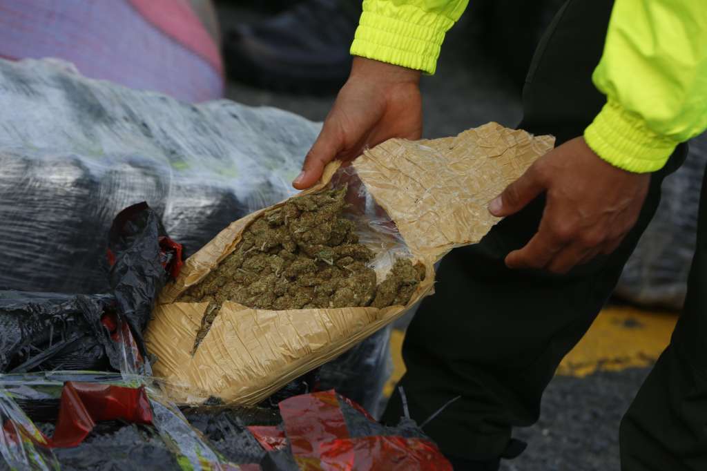 AME7935. CALI (COLOMBIA), 12/03/2024.- Un policía abre un paquete que hace parte de un cargamento de marihuana decomisado en un operativo, en Cali (Colombia). Las autoridades colombianas incautaron 5,6 toneladas de marihuana en una operación realizada en un barrio del norte de Cali, en el suroeste del país, informó hoy la Policía. La marihuana incautada, que iba a ser distribuida en varias zonas de Cali, la tercera ciudad de Colombia, está avaluada en 1.970 millones de pesos (unos 500.000 dólares), según la Policía, que no indicó si hubo detenidos. EFE/ Ernesto Guzmán